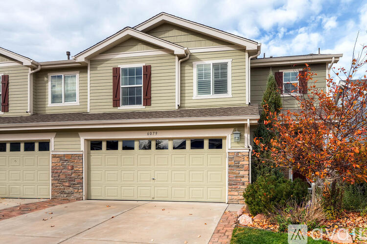 A two-story house with a garage and a driveway.