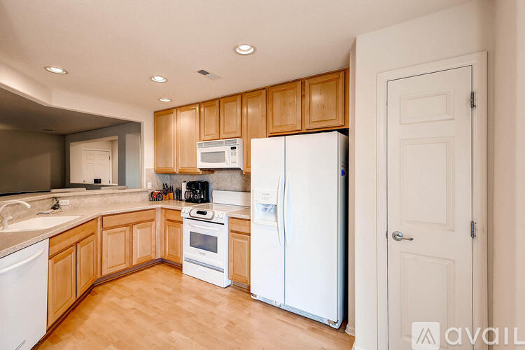 A kitchen with wooden cabinets and white appliances.