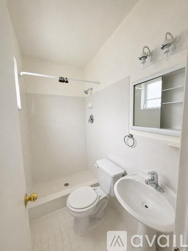 A white bathroom with a toilet, sink and shower.