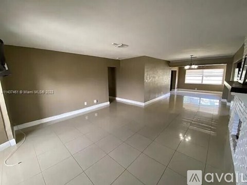 A spacious room with a tiled floor and a window letting in natural light.