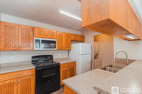 A kitchen with wooden cabinets and a black stove top oven.