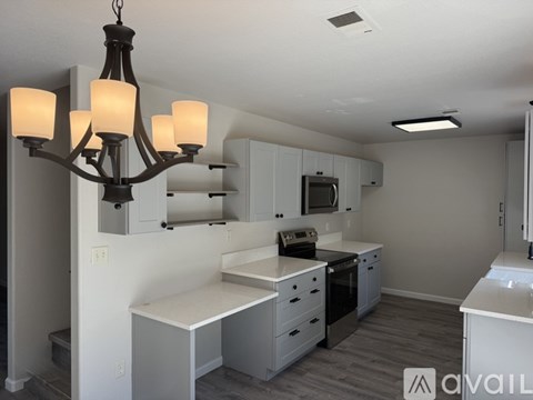A kitchen with a white counter and a chandelier.