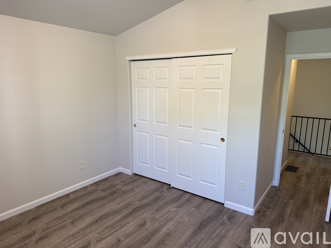 A white double door is in a room with wood flooring.