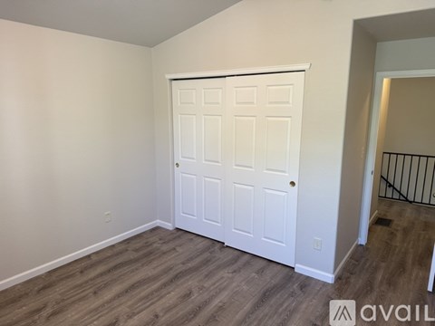 A white double door is in a room with wood flooring.