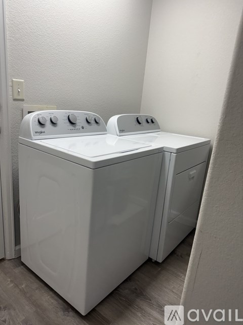A white front loading washing machine in a laundry room.