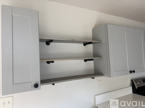 A kitchen with grey cabinets and a shelf.