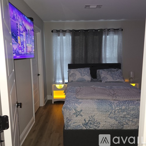A bedroom with a bed, a television, and a lamp.