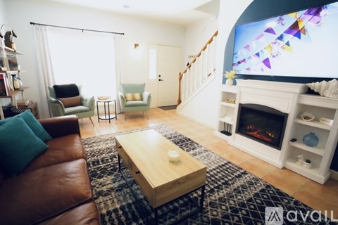 A living room with a brown leather couch, a coffee table, and a fireplace.