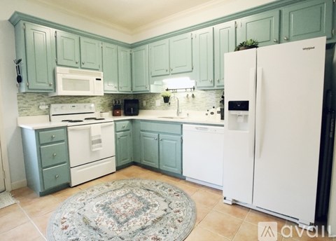 A kitchen with a white refrigerator and white appliances.
