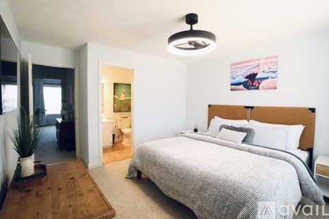 A bedroom with a large bed and a ceiling fan.