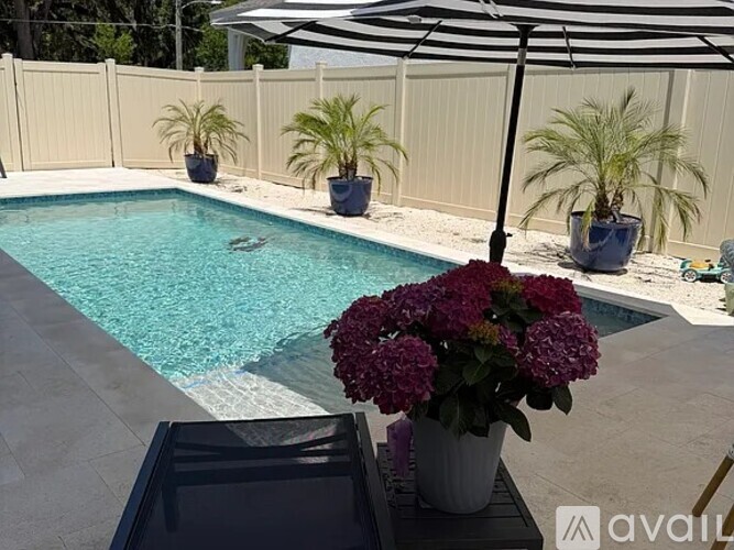 A pool with a fence and a potted plant.
