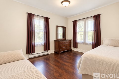 A bedroom with a bed, dresser, and mirror.