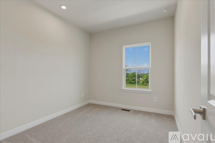 A room with a window showing a view of trees and sky.