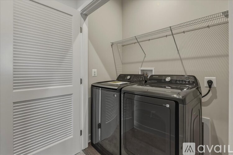 A modern kitchen with a double oven and a white door.