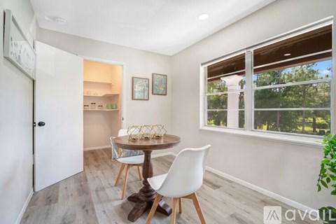 A dining room with a table and chairs.