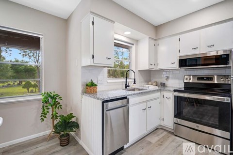 A kitchen with white cabinets and stainless steel appliances.