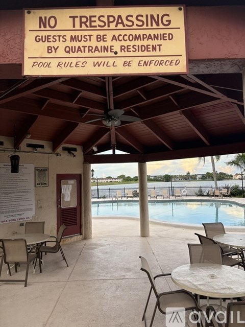 A pool area with a sign that says "No Trespassing" and "Guests must be accompanied by Quatraine, resident.".
