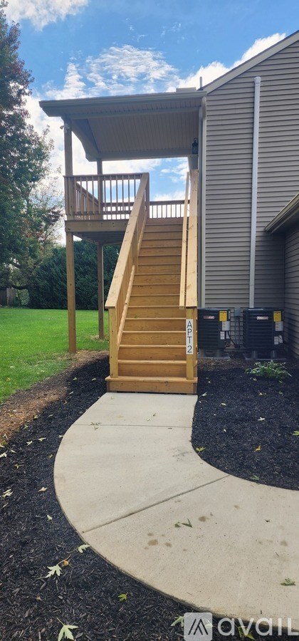 A wooden deck with a staircase leading to a house.