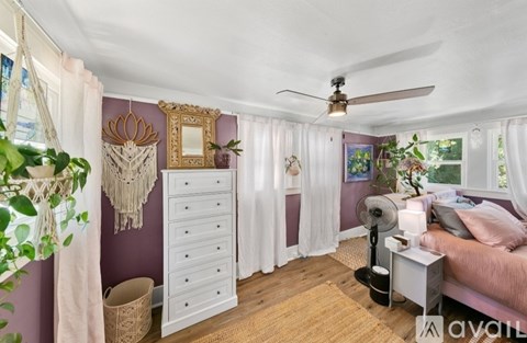 A bedroom with a bed, dresser, and mirror.
