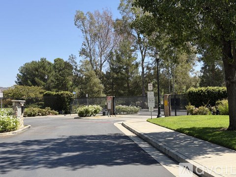 A gated entrance to a park with a sign on the gate.