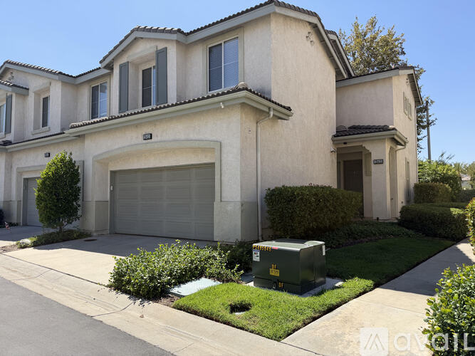 A two-story house with a garage and a driveway.