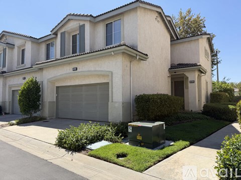 A two-story house with a garage and a driveway.