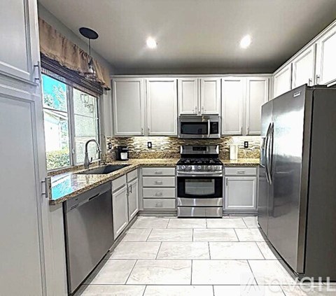 A kitchen with white cabinets and stainless steel appliances.
