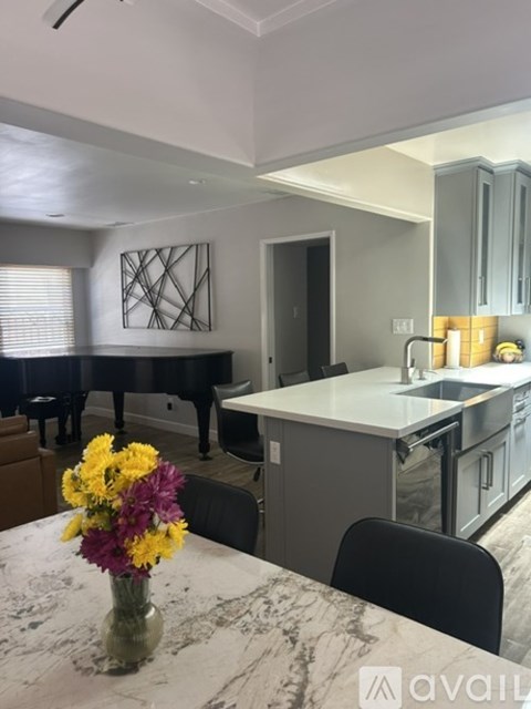 A kitchen with a marble table and a vase of flowers on it.
