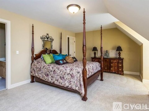 A bedroom with a four poster bed and a dresser.