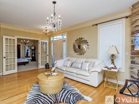 A living room with a white couch, a wooden coffee table, and a zebra print rug.
