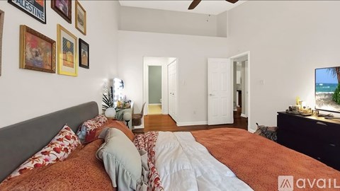 A bedroom with a large bed and a flat screen TV on the wall.