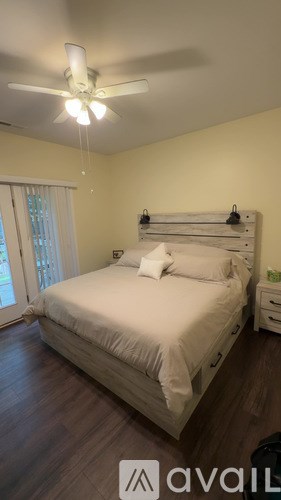 A bedroom with a bed, nightstand, and window.