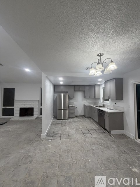 A kitchen with a refrigerator, sink, and cabinets.