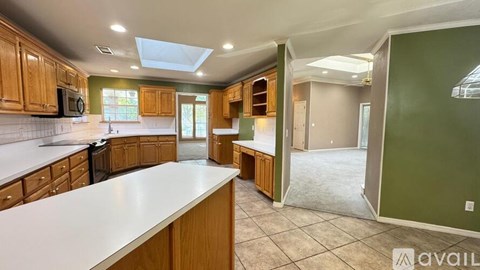 A kitchen with wooden cabinets and a white countertop is available for rent.