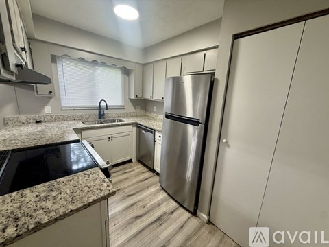 A kitchen with a granite countertop and stainless steel appliances.