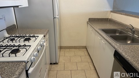 A kitchen with a white stove top and a granite counter top.