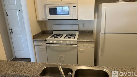A kitchen with a stove, microwave, and refrigerator.