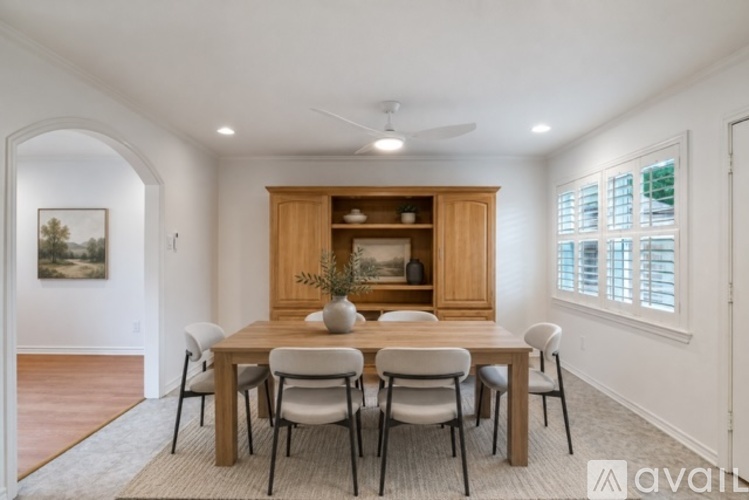 A dining room with a wooden table and chairs.