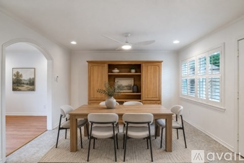 A dining room with a wooden table and chairs.