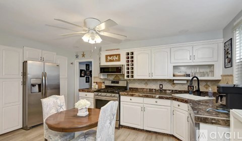A kitchen with a table and chairs and a fridge.