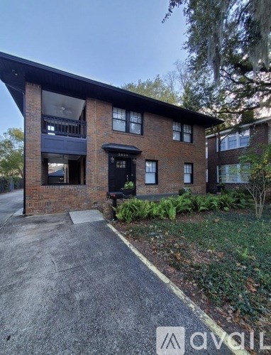 A brick house with a black door and windows.