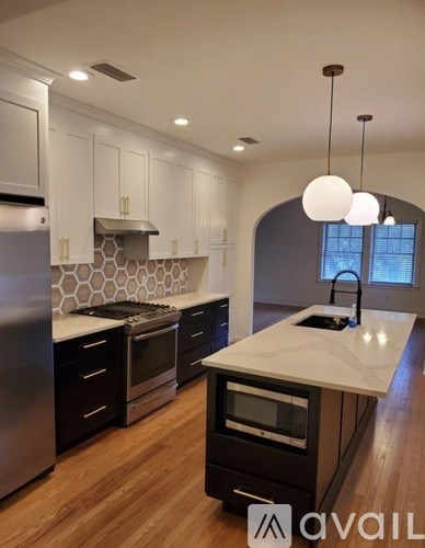 A modern kitchen with a large island and stainless steel appliances.