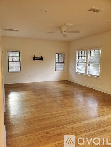 A room with wooden flooring and a ceiling fan.