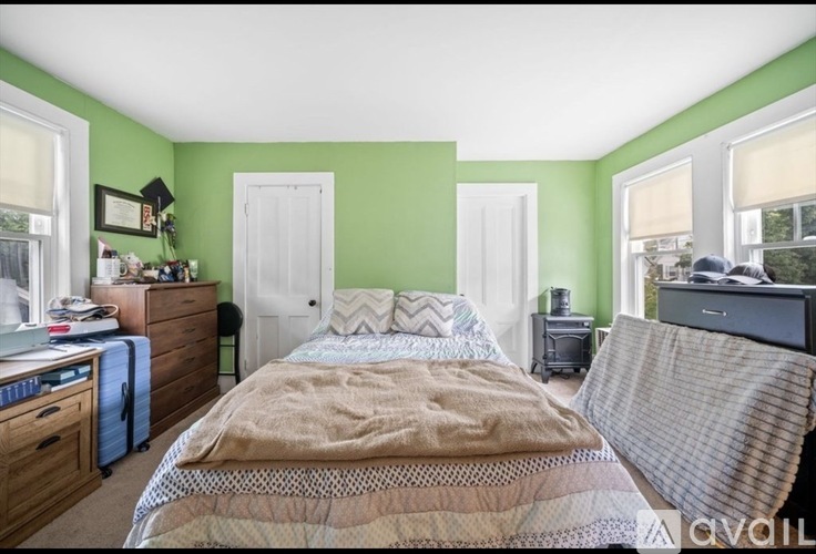 A bedroom with a bed, a dresser, and a window.