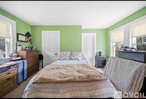 A bedroom with a bed, a dresser, and a window.