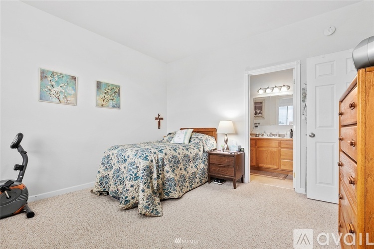 A bedroom with a bed, dresser, and a mirror.