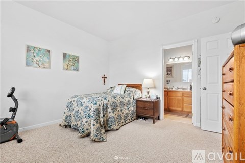 A bedroom with a bed, dresser, and a mirror.