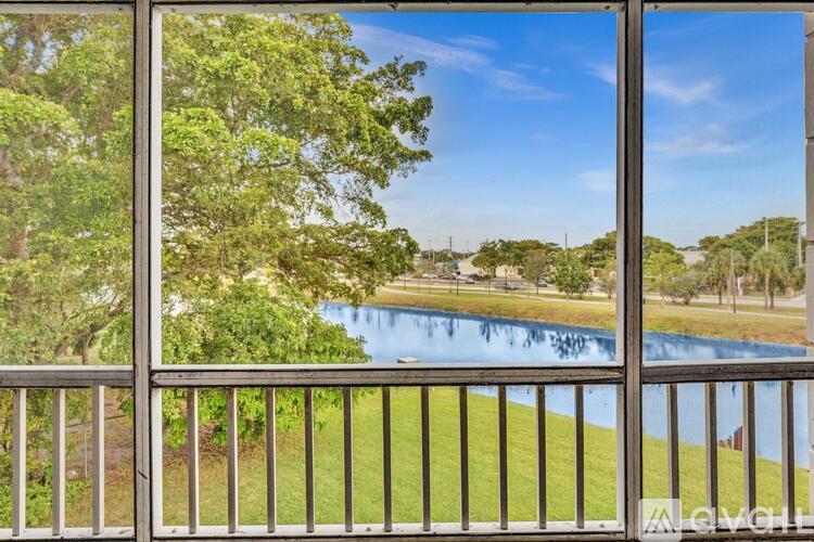 A view from a balcony looking out at a pool and trees.