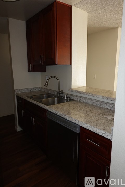 A kitchen with brown cabinets and a granite countertop.