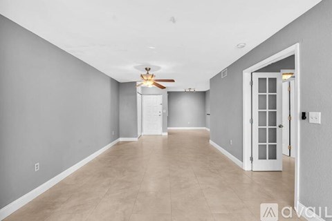 A spacious room with a ceiling fan and light fixture.